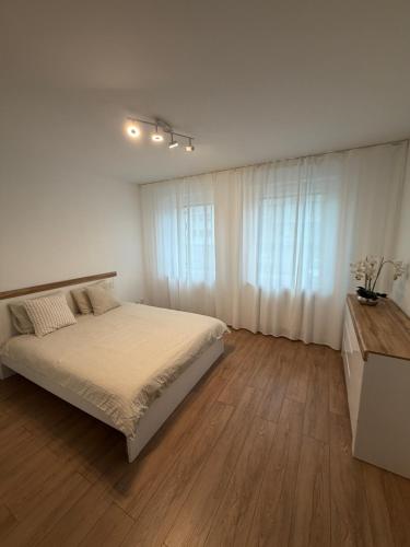 une chambre blanche avec un lit et un parquet dans l'établissement Apartament 8, à Łobez