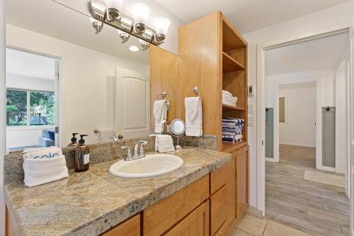 un bagno con un lavandino e un grande specchio di 2 Landrise a Sunriver