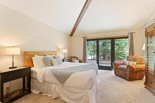 a bedroom with a bed and a chair and a window at 10 Tan Oak in Sunriver
