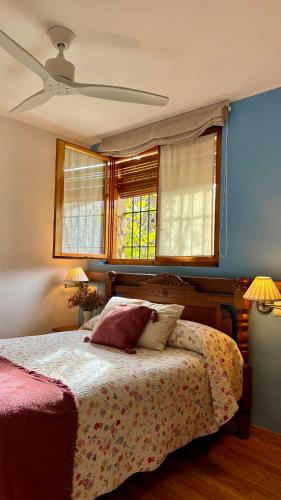 a bedroom with a bed and two windows at Casa Laiglesia in Uncastillo