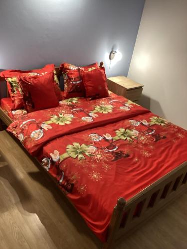 a bed with a red comforter and red pillows at Natura A1 in Medulin
