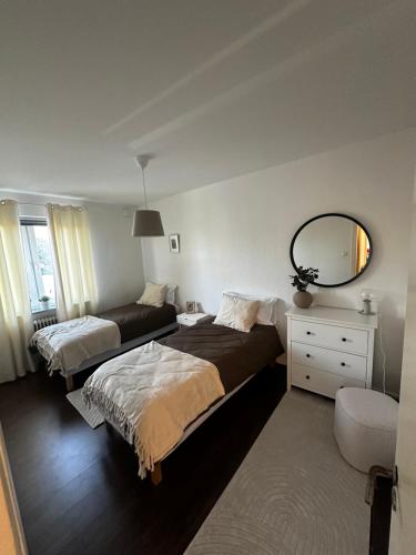 a bedroom with two beds and a mirror at Apartment close to city in Malmö