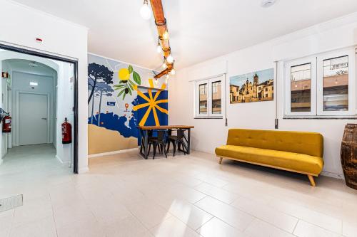 a living room with a yellow couch and a table at Arbutus Bed and Bar in Portimão