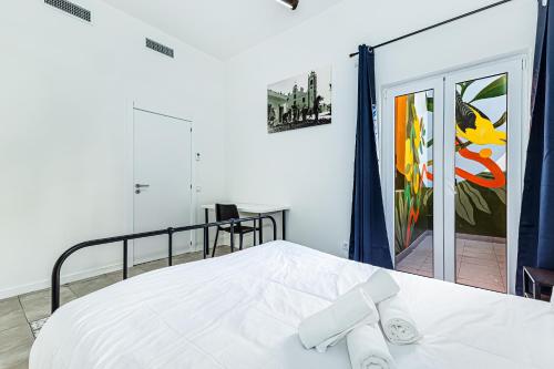 a bedroom with a white bed with towels on it at Arbutus Bed and Bar in Portimão