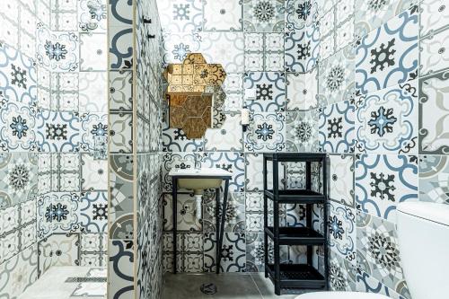 a bathroom with blue and white tiles on the wall at Arbutus Bed and Bar in Portimão