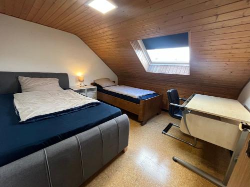 une chambre avec un lit, un bureau et une fenêtre dans l'établissement Beishan Appartements Nürnberg in Zentrum Dachgeschoss, à Nuremberg