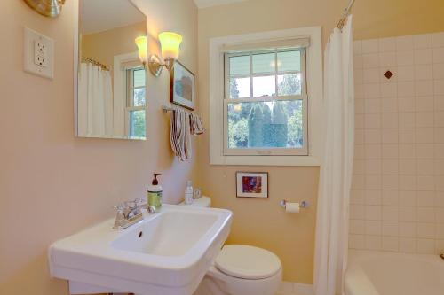 a bathroom with a sink and a toilet and a window at Living Color Cottage in Hood River