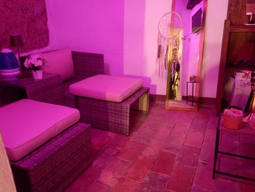 a living room with pink walls and chairs and tables at The secret room in Pitigliano