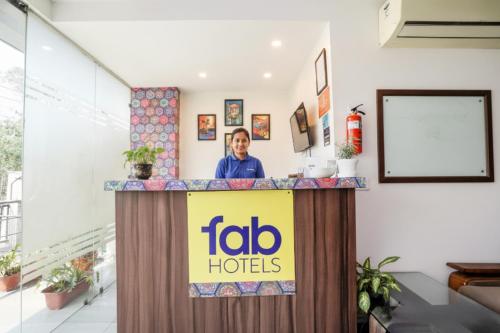 a woman standing behind a podium with a td hotels sign at FabHotel Emoji Stays in Gurgaon