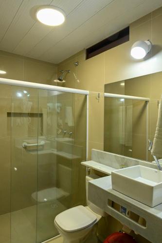a bathroom with a shower and a toilet and a sink at Pousada Shalom Beach in Maragogi