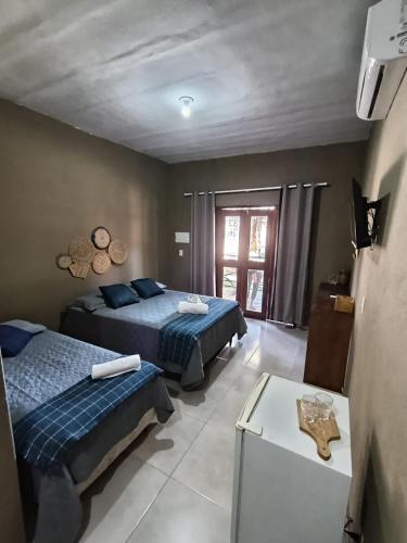 a bedroom with two beds and a table at Mar Doce Lar - Praia Macapa in Luis Correia