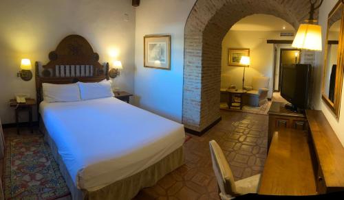 a bedroom with a bed and a television in a room at Parador de Plasencia in Plasencia
