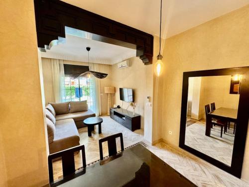 Una sala de estar con un sofá y un espejo. en Calm Garden Retreat - Private Patio, BBQ, Pool Access & Free Breakfast, en Marrakech