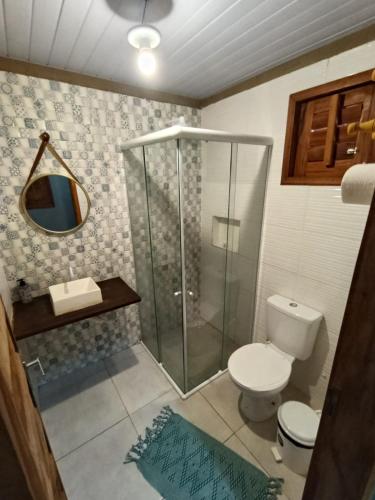 a bathroom with a shower and a toilet and a sink at Mar Doce Lar - Praia Macapa in Luis Correia