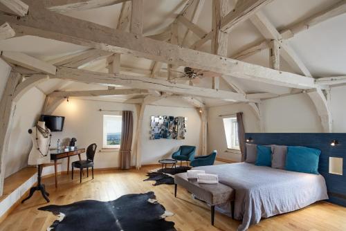 a bedroom with a bed and a desk and chairs at Maison d'hôtes La Chevalée in Hautvillers