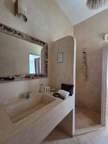 Un baño con una bañera grande y un espejo. en Kupenda House - Milele Resort Tamu, Watamu, en Watamu