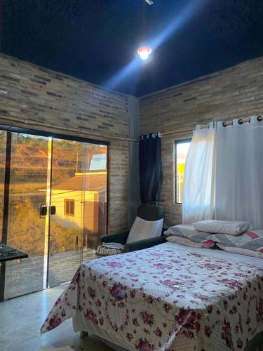a bedroom with a bed and a large window at Hostel Fabulosa Casa de tijolinhos in Arapiraca