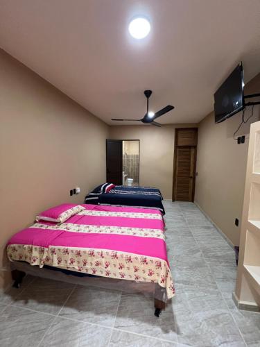 a bedroom with a large bed and a ceiling fan at Hotel las flores in Santa Cruz Huatulco