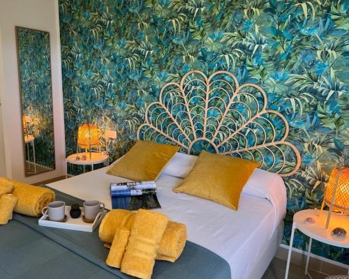 a bedroom with a large bed with a tropical wallpaper at Corralejo Tender Suite in Corralejo
