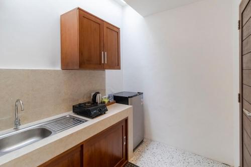 Una pequeña cocina con fregadero y microondas. en Taman Bali Homestay, en Sanur