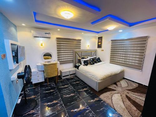 Un dormitorio con cama, escritorio y televisión. en DreamBay Homes, en Isheri-Olofin