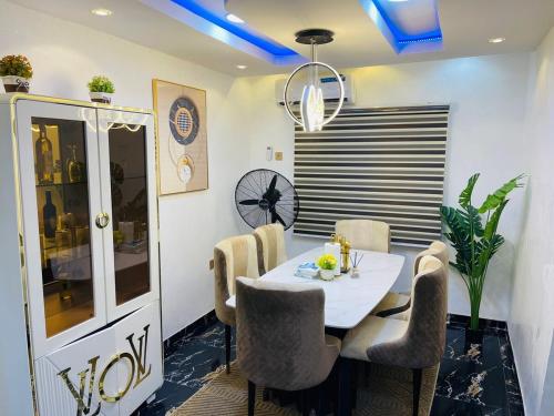 a dining room with a white table and chairs at DreamBay Homes in Isheri-Olofin