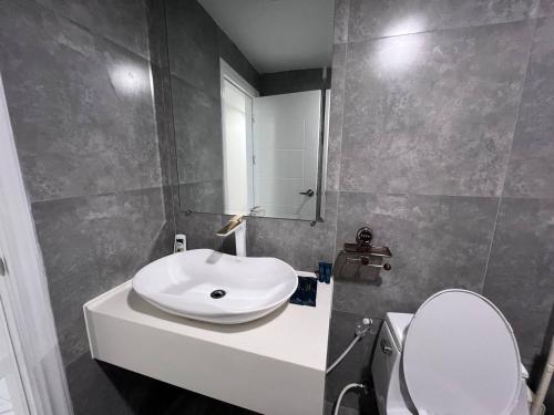 ein Badezimmer mit einem weißen Waschbecken und einer Toilette in der Unterkunft STAY 27th in Phnom Penh