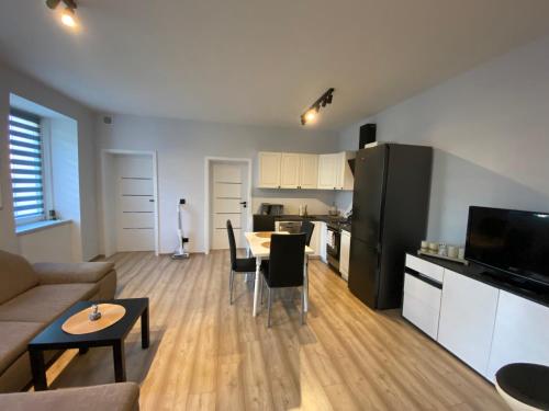 a living room with a couch and a table and a kitchen at MIESZKANIE APRTEMNT DO WYNAJECIA na doby Bolesławiec in Bolesławiec