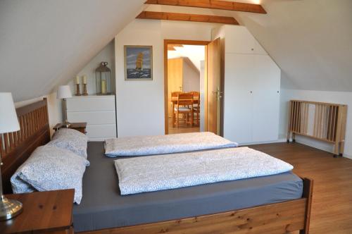 FeWo Oland في Hattstedt: سريرين في غرفة مع علية