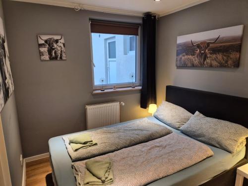 une chambre avec un lit et une fenêtre dans l'établissement Stadtnah an der Förde 5703, à Flensbourg