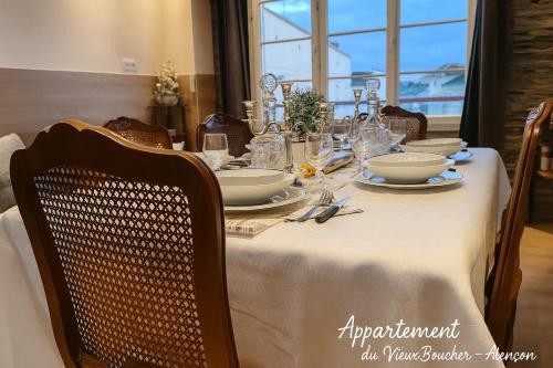- une table à manger avec un chiffon de table blanc dans l'établissement Magnifique Appartement du Vieux Boucher 3 chambres à Alençon, à Aleçon