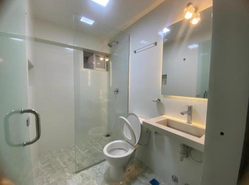a bathroom with a toilet and a sink and a shower at Amaca Hostal in Santa Cruz de la Sierra