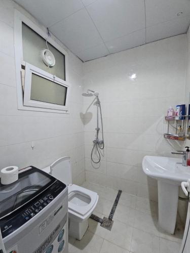 a bathroom with a toilet and a sink at Studio towam hospital 2 in Al Ain