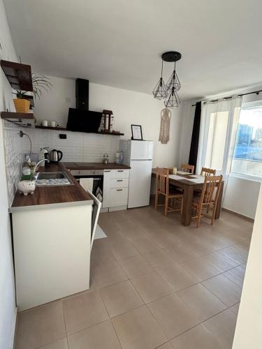 a kitchen with a sink and a table with chairs at White House Apartments - Boho in Haskovo