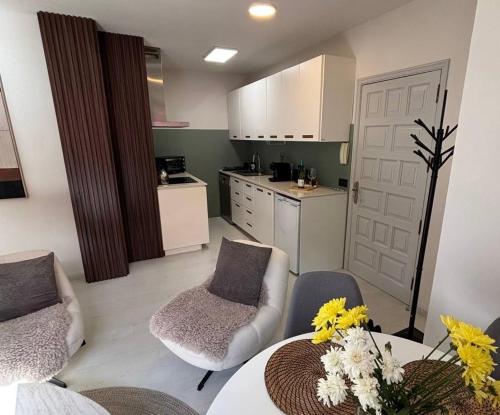 a living room with a table and chairs and a kitchen at Buganvilla Garden Puerto de la Cruz in Puerto de la Cruz