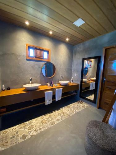 a bathroom with two sinks and a large mirror at Vivi Beach Macapá in Luis Correia