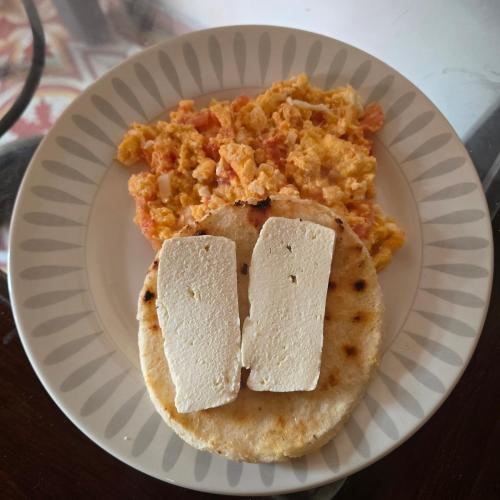 Un plato de comida con un panqueque y queso. en Finca La Preciosura, en El Peñol