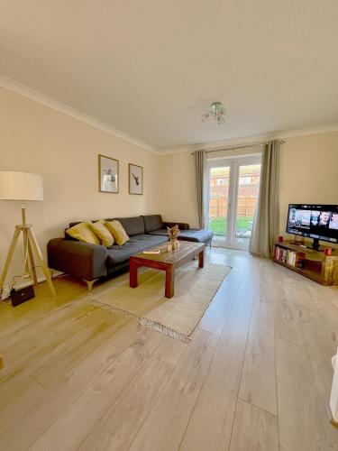 a living room with a couch and a tv at Guildford Townhouse with Parking in Guildford