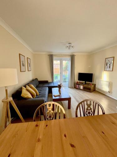 a living room with a couch and a table at Guildford Townhouse with Parking in Guildford