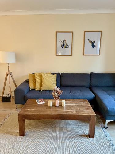 a living room with a blue couch and a coffee table at Guildford Townhouse with Parking in Guildford