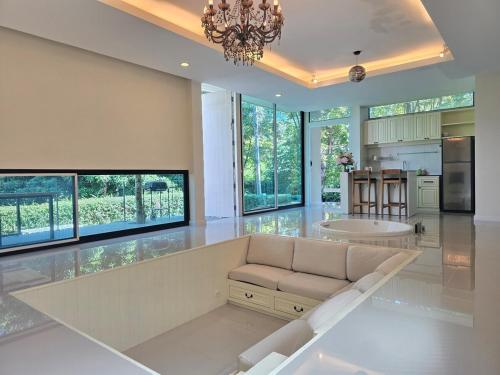 ein großes Wohnzimmer mit Couch und Küche in der Unterkunft Relax home surrounded by nature near town 15 min in Chiang Mai