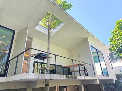 ein großes Haus mit einem Baum auf dem Balkon in der Unterkunft Relax home surrounded by nature near town 15 min in Chiang Mai