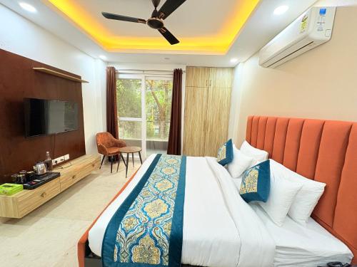 una habitación de hotel con una cama y un televisor en The Nuvon Residency CR Park, en Nueva Delhi