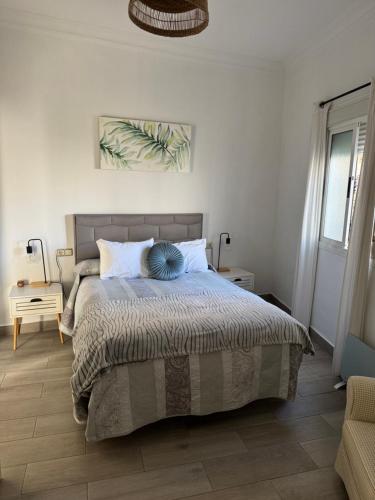 a bedroom with a large bed and a chair at Casa isabel in Setenil