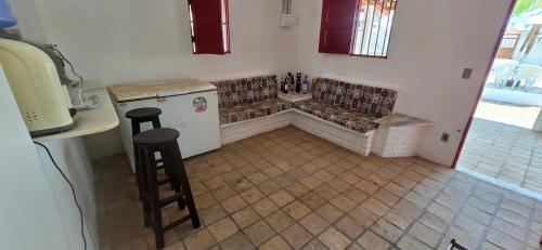 eine Küche mit Couch, Tisch und Hocker in der Unterkunft Casa de praia com área de lazer in Nísia Floresta
