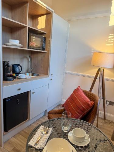 a living room with a table and a kitchen at Westwood Boutique Aparthotel by Birch Stays in Glossop