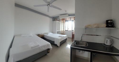 a room with two beds and a desk and a window at Hospedaje Luciana in Pucallpa