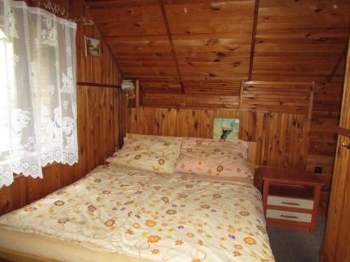 a bedroom with a bed in a room with wooden walls at Chalupa u Jizery in Rokytnice nad Jizerou