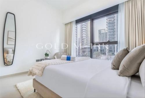 a bedroom with a large white bed and a large window at Stunning One bed Dubai mall downtown in Dubai