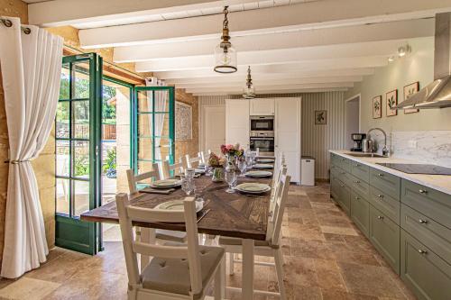a dining room with a table and chairs in a kitchen at La Mouy - Périgord Noir - Farmhouse with pool in Mauzens-et-Miremont